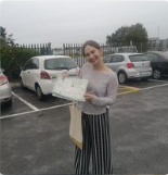 Learner standing beside a driving school car